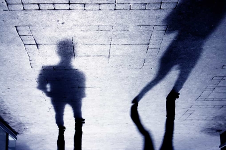 Ominous shadows of two people in an alley