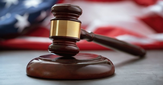 Close up of wooden judge gavel over the American flag
