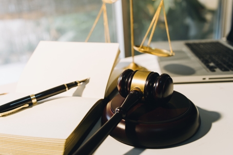 contract papers with brass scale on desk in office