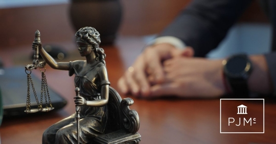 Statue of justice on the table against the background of the hand gestures of a man, a lawyer or a judge